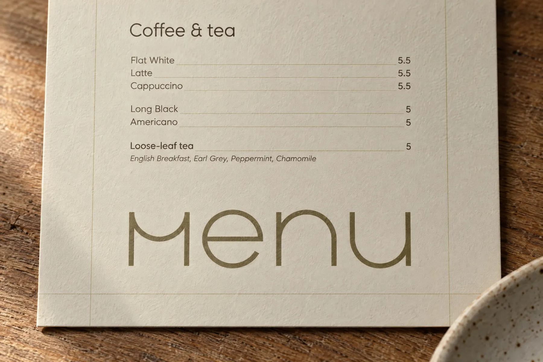 The coffee and tea list and the large olive "Menu" lettering on the cream side of the Kōwhai menu card.